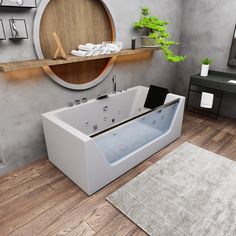 a large white bath tub sitting on top of a wooden floor next to a tv