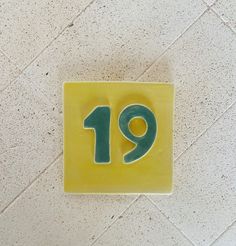 Beautiful original unique boho quirky custom made tile o with green number and yellow background. you can choose up to 3 numbers, the 3 number option is slighly wider than the pictured one (which is 14 x14 Cm) You can reverse the colours ( yellow number / green background )  High temperature clay for extra strenght.  Although the tile is ment to be glued on the wall as a traditional tile hanging holes are optional for example if you have a stone wall this might be needed.  Attention : when order Boho Tile, Unique House Numbers, Tile House Numbers, Modern House Numbers Sign, Boho Tiles, Tile House, Number Tiles, Ceramic House Numbers, 3 Number