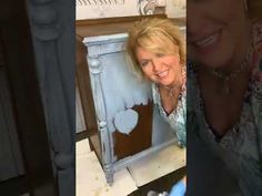 the woman is smiling and posing in front of her fireplace