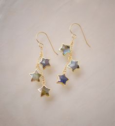 Hello Star Gazer! These earrings were designed with you in mind! Handcrafted with natural Labradorite shaped into stars, these light-weight dangle earrings are perfect for anything. Each stone is naturally gray and contains a blue to green flash when turned from side to side. The ear wires are 14k gold filled or sterling silver and come with rubber backs. GEMSTONE: Natural Labradorite STAR SIZE: average 12mm (.5") METAL: 14k gold filled or sterling silver EXTRAS - Each earring is handcrafted to Silver Celestial Earrings, Star Earrings Aesthetic, Gold Star Earrings, Celestial Earrings, Earrings Gemstone, Labradorite Earrings, Dope Jewelry, Silver Dangle Earrings, Funky Jewelry