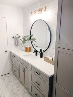 a bathroom vanity with a round mirror above it