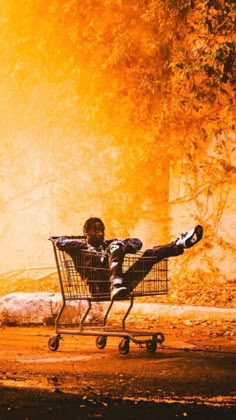 a man sitting in a shopping cart with his legs spread out and feet on the ground