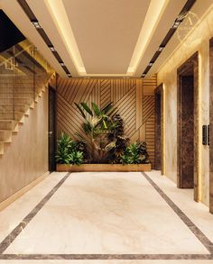 an empty lobby with stairs and plants on the wall