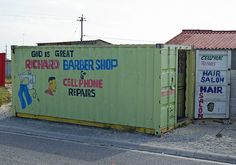 two shipping containers sitting on the side of a road