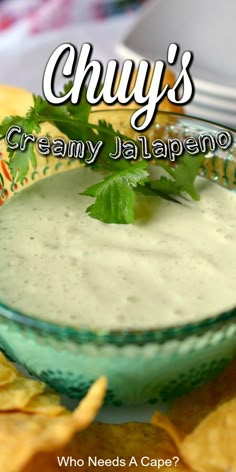 a green bowl filled with creamy jalapeno dip surrounded by tortilla chips