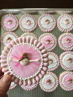 a hand holding a tiny pink ballerina clock