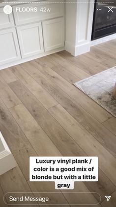 an image of a living room with wood flooring and white cabinets in the background