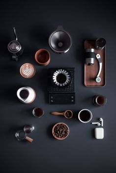 an assortment of coffee accessories on a black surface