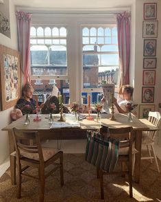 two children are sitting at a table with candles in front of them and looking out the window