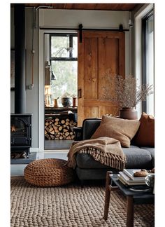 a living room filled with furniture and a fire place in front of a wooden door