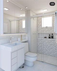 a white bathroom with a toilet, sink and shower stall in the middle of it