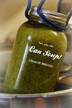 a jar filled with green stuff sitting on top of a stove