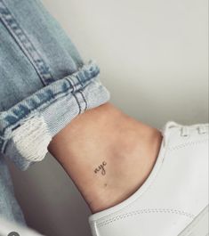 a woman's ankle with a small anchor tattoo on her left side ribcage