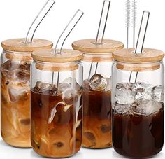 four mason jars filled with iced drinks and straws