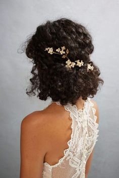 the back of a woman's head wearing a hair comb with flowers on it