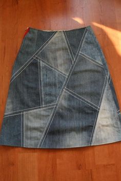 a skirt made out of jeans sitting on top of a wooden floor