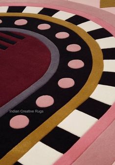 an area rug is shown with pink, black and white circles