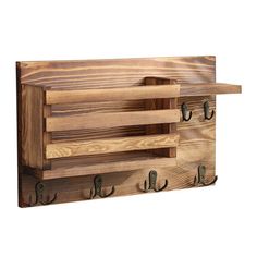 a wooden wall mounted shelf with hooks on it