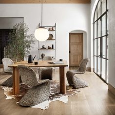 an image of a dining room setting with chairs and rugs on the wooden floor