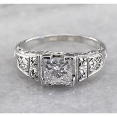 an antique style engagement ring with princess cut diamonds