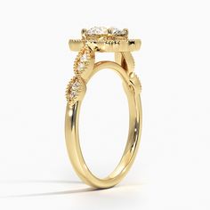 a yellow gold ring with three stones on the side and two rows of diamonds at the top