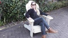 a woman sitting in a white chair outside