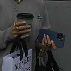 a woman holding a coffee cup and cell phone