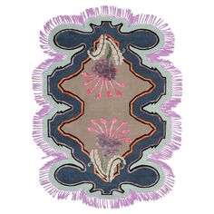 an area rug with fringes and flowers on the center in purple, green, pink and blue colors