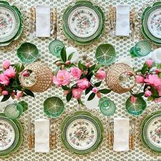 a table set with plates and flowers on it