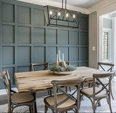 a dining room table with chairs and a chandelier hanging from it's ceiling