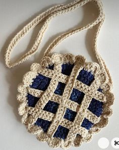 a crocheted bag with blue squares on it sitting on top of a table