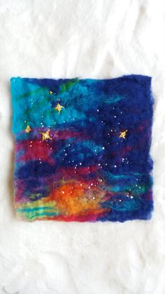 a piece of art that looks like it is made out of felt and has stars on it