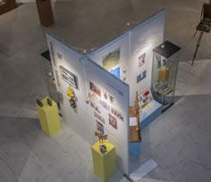 an overhead view of a museum exhibit with pictures on the walls and yellow pedestals