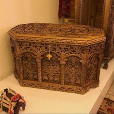 an ornate wooden chest with intricate carvings on the front and sides, next to a pair of shoes