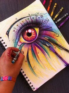 someone is drawing an eye with colored pencils