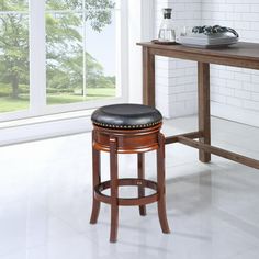 a kitchen with a counter, table and stools next to a window that looks out onto the yard