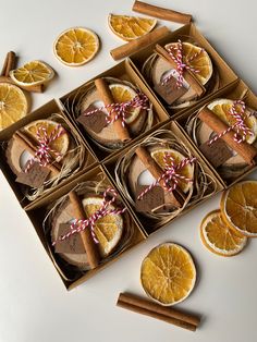 orange slices and cinnamon sticks are arranged in an open cardboard box on a white surface