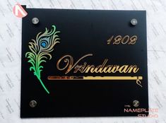 a black plaque with gold lettering and a peacock feather on the front that says windjaan