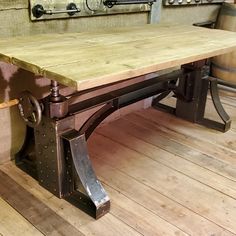 a large wooden table sitting on top of a hard wood floor next to two wine barrels