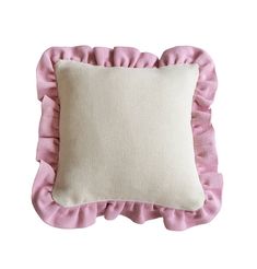 a pink and white pillow with ruffles on the bottom, against a white background