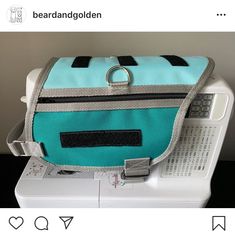 a blue and grey bag sitting on top of a sewing machine