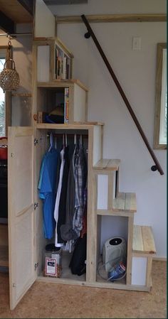 an open storage unit with clothes hanging on it