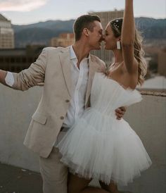 a man and woman dressed in white posing for the camera with their arms around each other