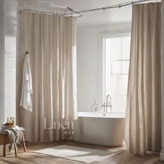 a white bath tub sitting under a window next to a wooden table and chair in front of it