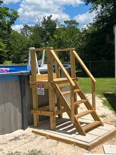 a wooden ladder next to an above ground swimming pool