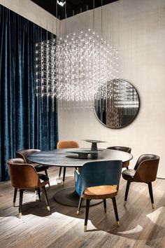 a dining room table with chairs and a chandelier hanging from it's ceiling