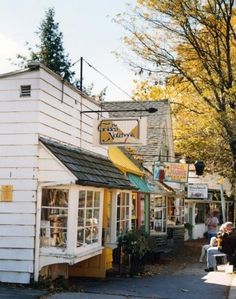 a small white building sitting on the side of a road