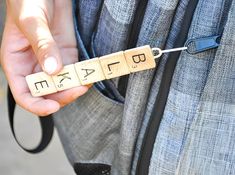 a person holding a piece of wood with letters on it