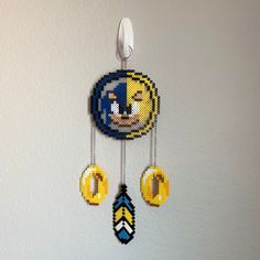 a beaded clock hanging from the side of a wall