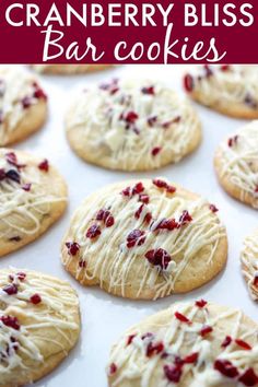 cranberry bliss bar cookies on a baking sheet with white icing and cranberries